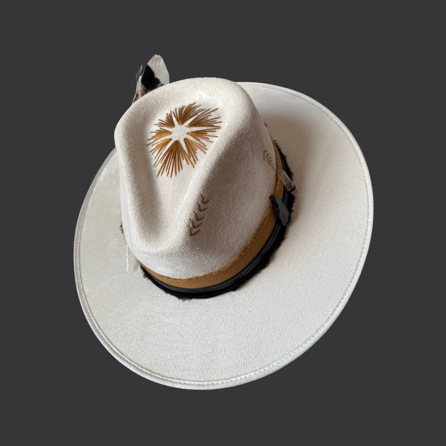 Front view of ivory boho fedora with black leather band, burnt orange cotton wrap, and turkey feather
