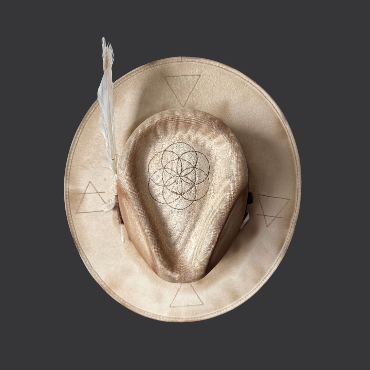 Cream wide-brim vegan suede fedora with Seed of Life and Four Elements pyrography, brown leather band, feather, and crystal arrow / top view
