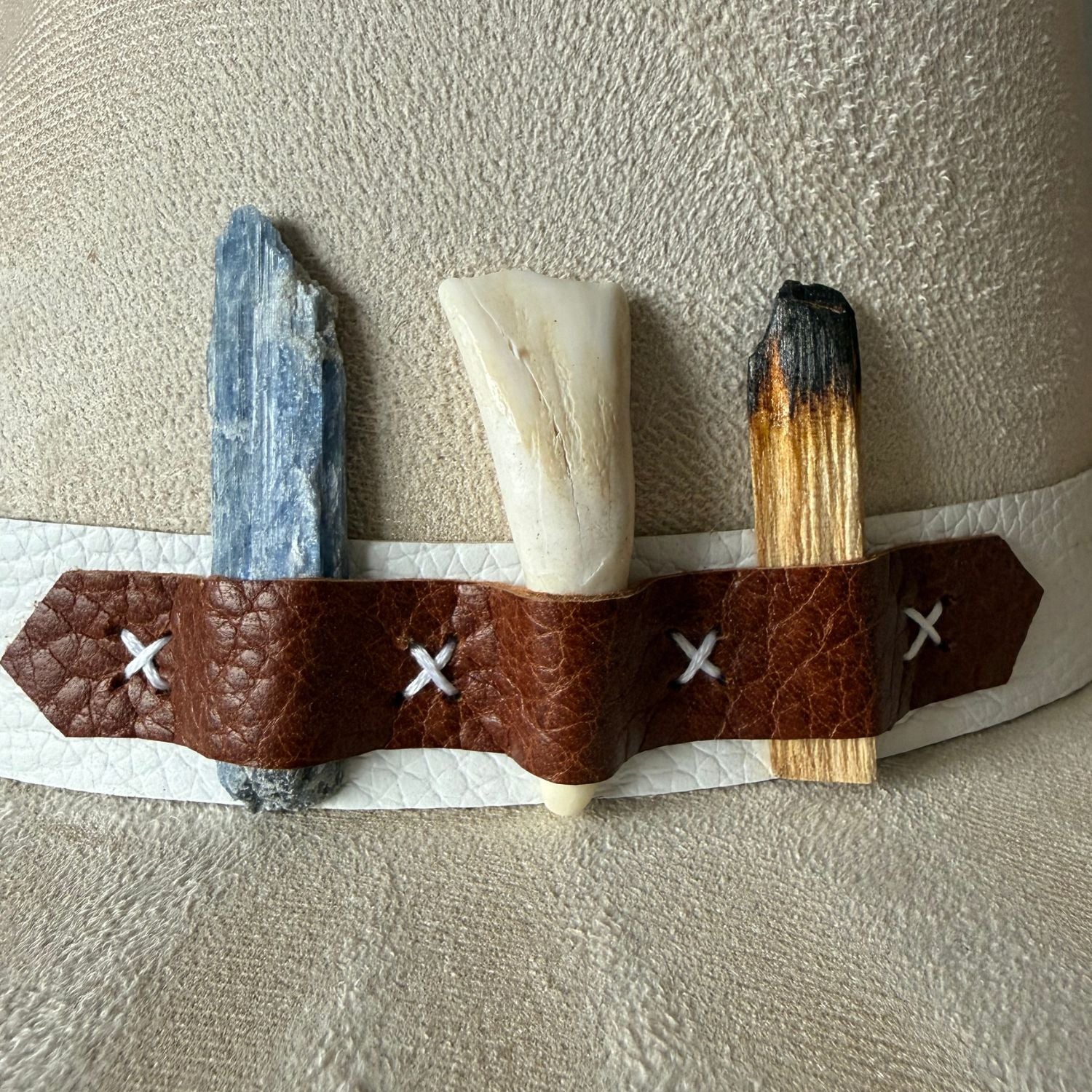 Ivory fedora boho hat with bison tooth, blue kyanite, and palo santo/ close up