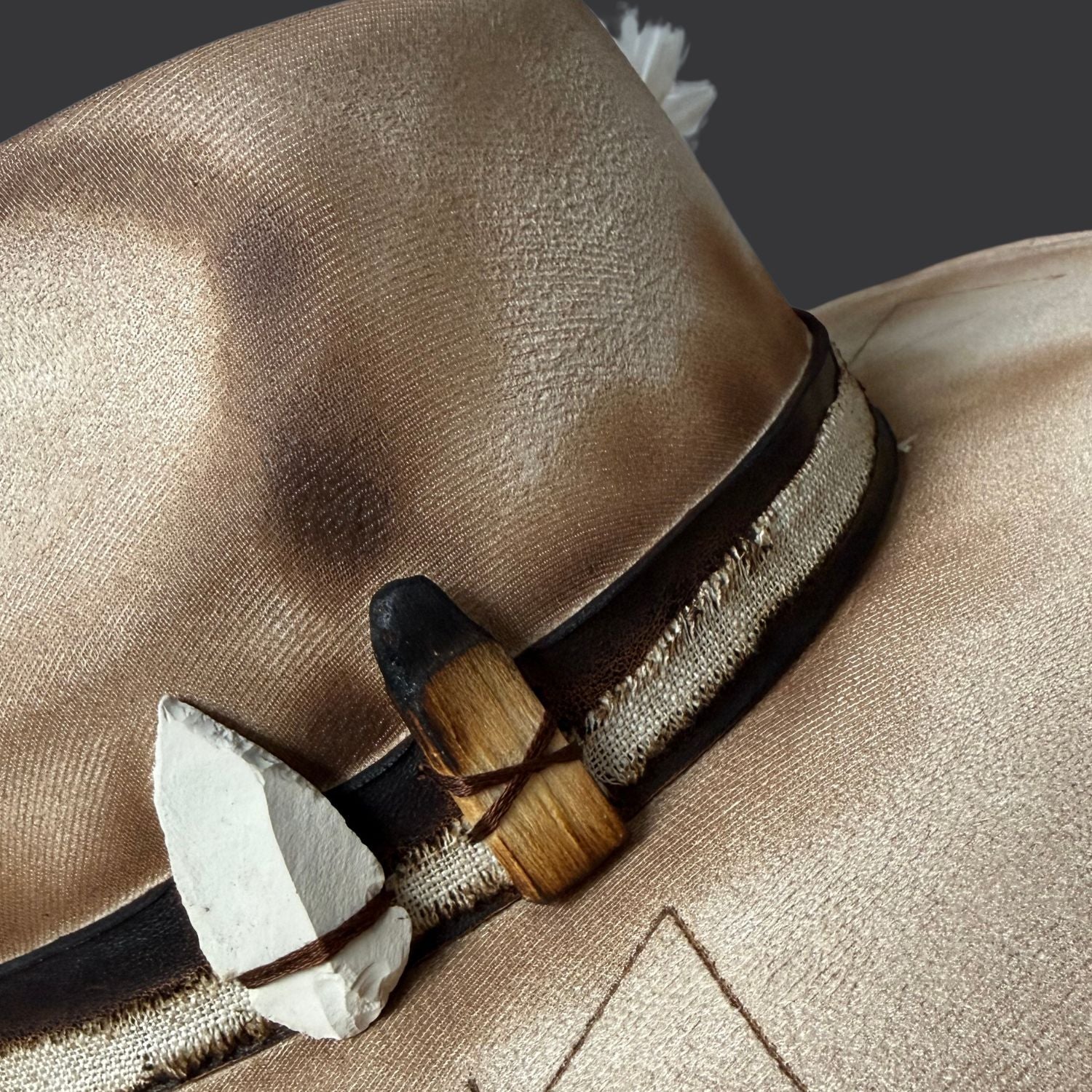 Cream wide-brim vegan suede fedora with Seed of Life and Four Elements pyrography, brown leather band, feather, and crystal arrow /close up