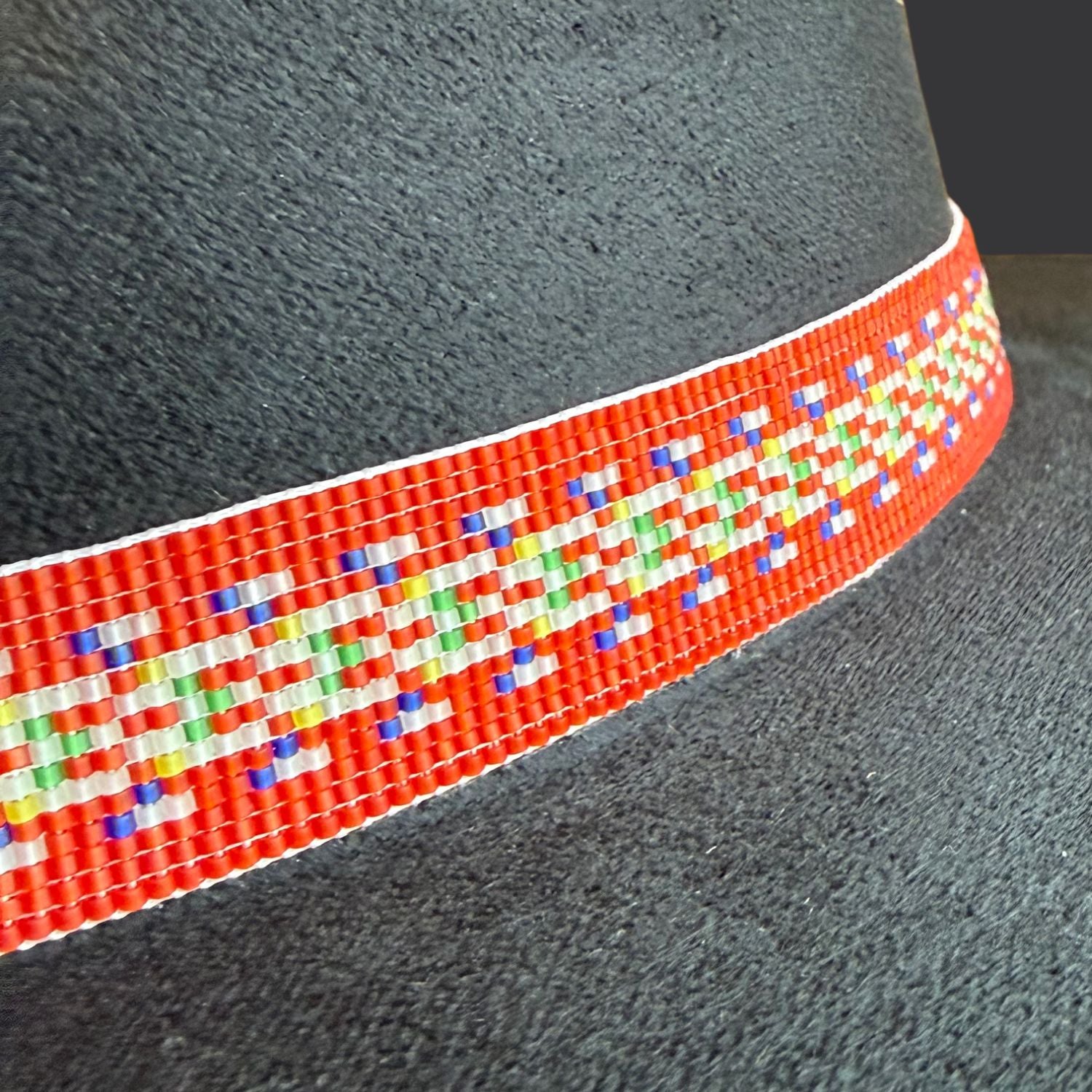 Close up of Red River Métis beaded sash by Shanelle St. Hilaire on black cordobés hat representing ancestry and resilience