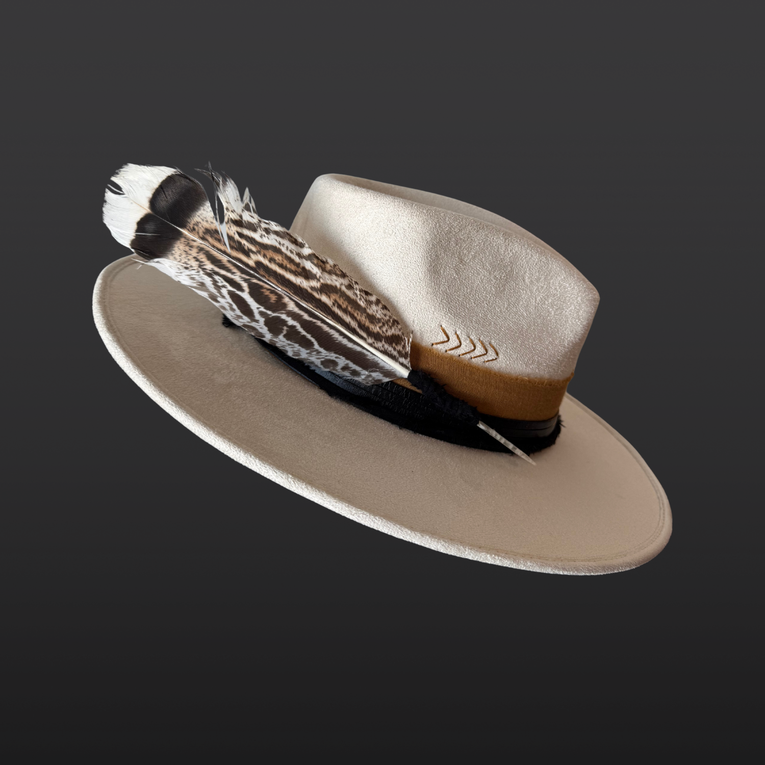 Left side view of ivory wide-brim fedora hat with sunburst embroidery, Lemurian quartz, obsidian arrow, leather band and feather detail