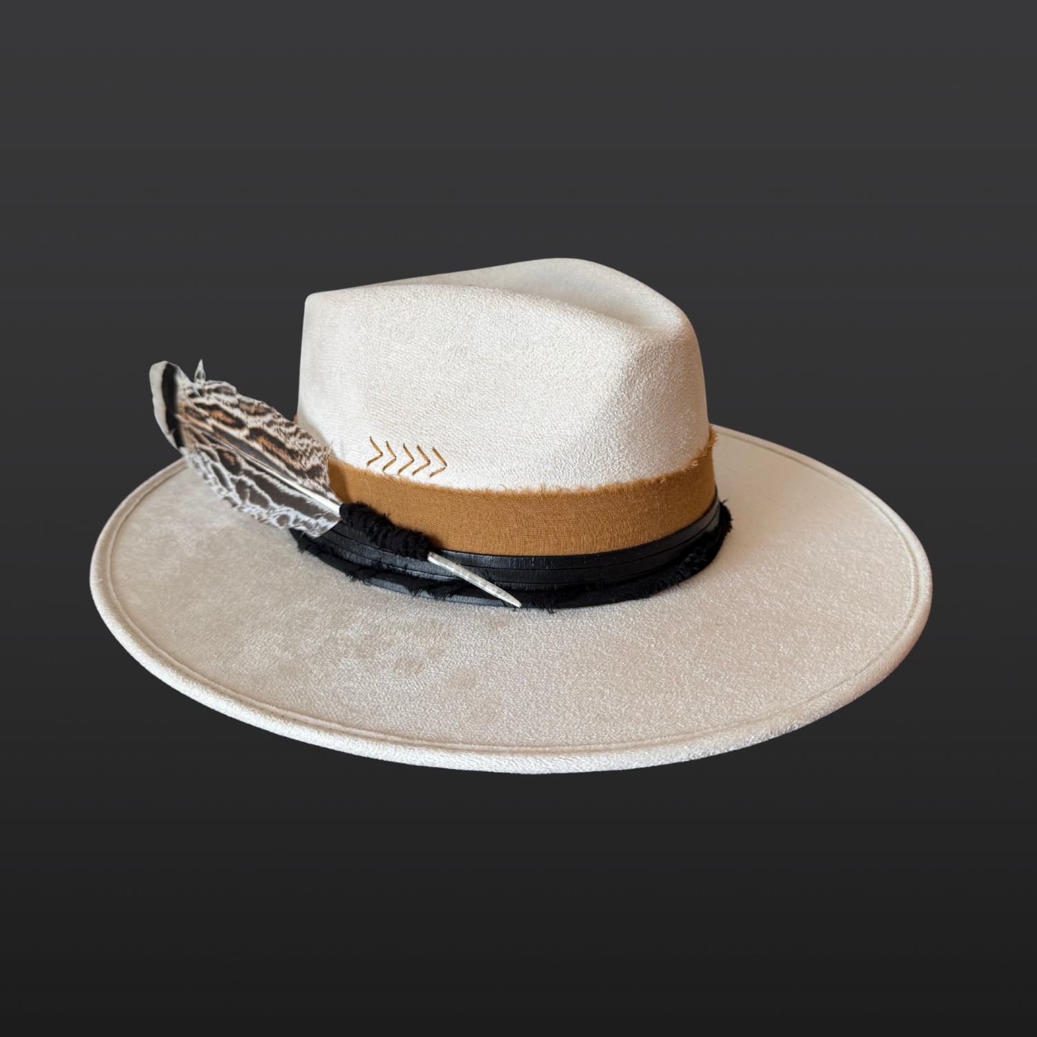 Left side view of ivory wide-brim fedora hat with sunburst embroidery, Lemurian quartz, obsidian arrow, leather band and feather detail
