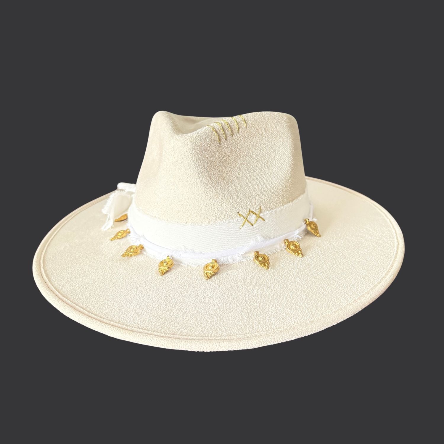 Ivory wide-brim fedora with gold hand-painted designs, white cotton band, and gold charm accents / front view