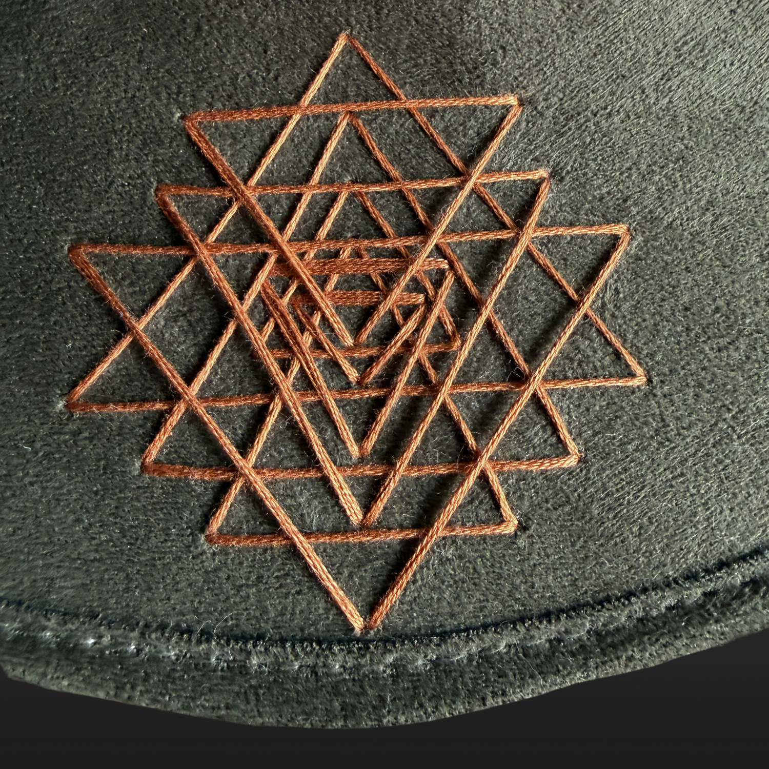 Close-up of Sri Yantra embroidery on the brim of the Root & Radiance sacred geometry fedora