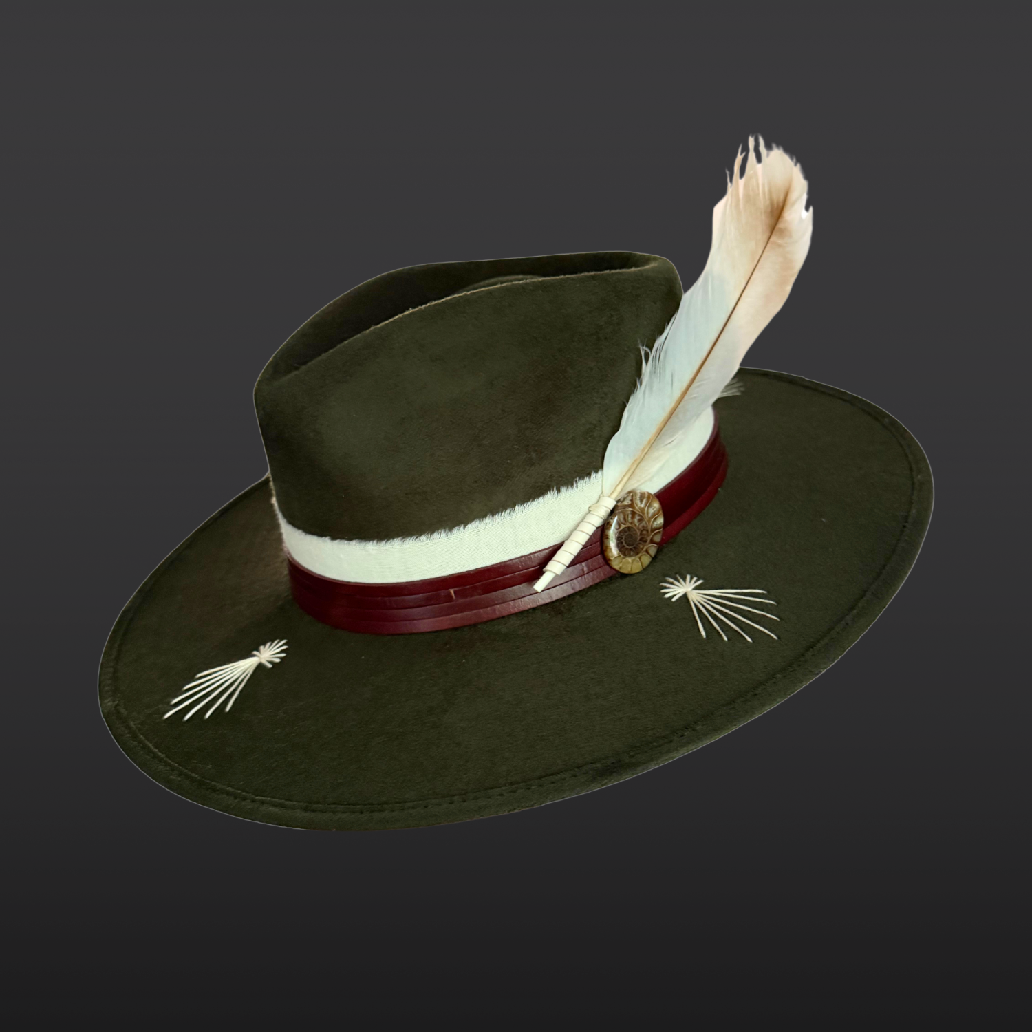 Left Side view of Kindred forest green fedora hat with ivory embroidery, leather band and fossil ammonite