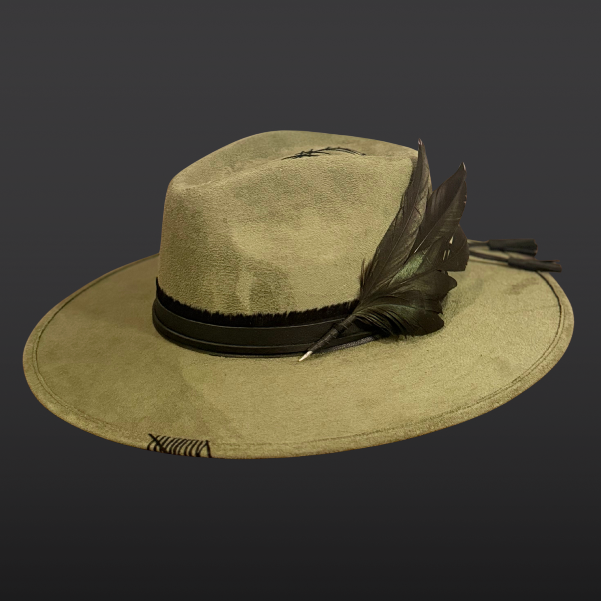 Left Side view: A sage green wide-brimmed fedora shown from the side, featuring a hand-embroidered arrow, black leather band with tassels, and rooster feather accents.