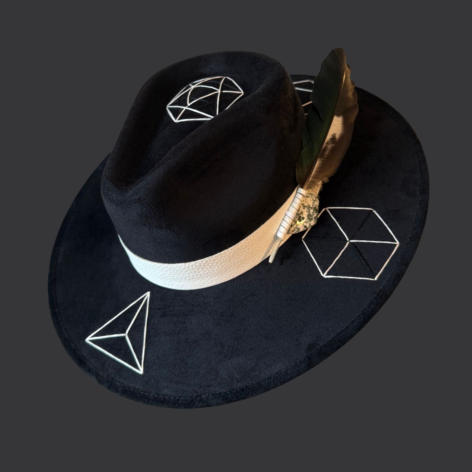 Black suede wide brim fedora with tree agate crystal, white leather band, and green black white duck feather / right side view