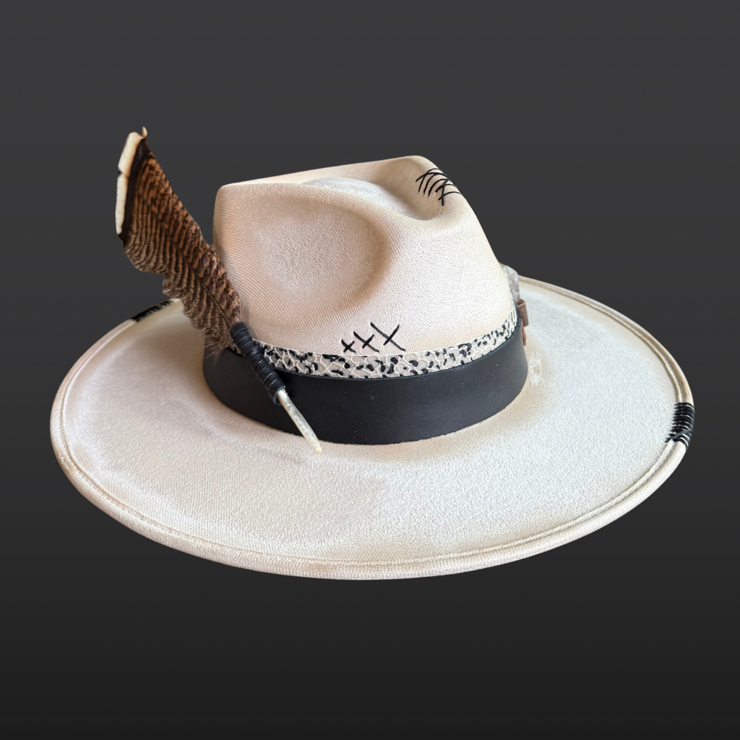left side view of Unbound ivory wide brim fedora hat featuring black embroidered details and a rugged hand-torched finish.