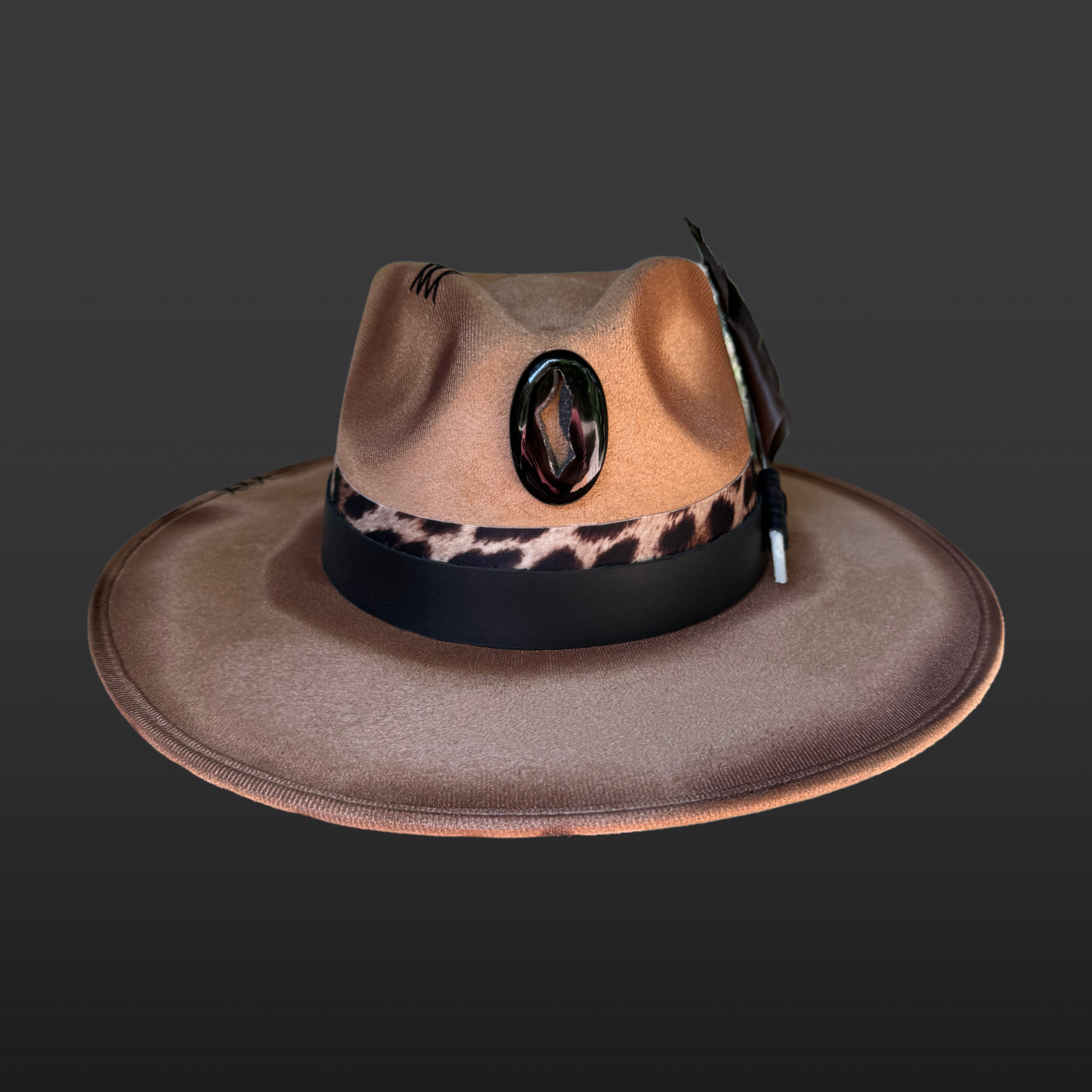 Front view of camel wide-brim fedora featuring hand-burned artwork, black agate onyx druzy, crow feathers, and animal-print leather accents.