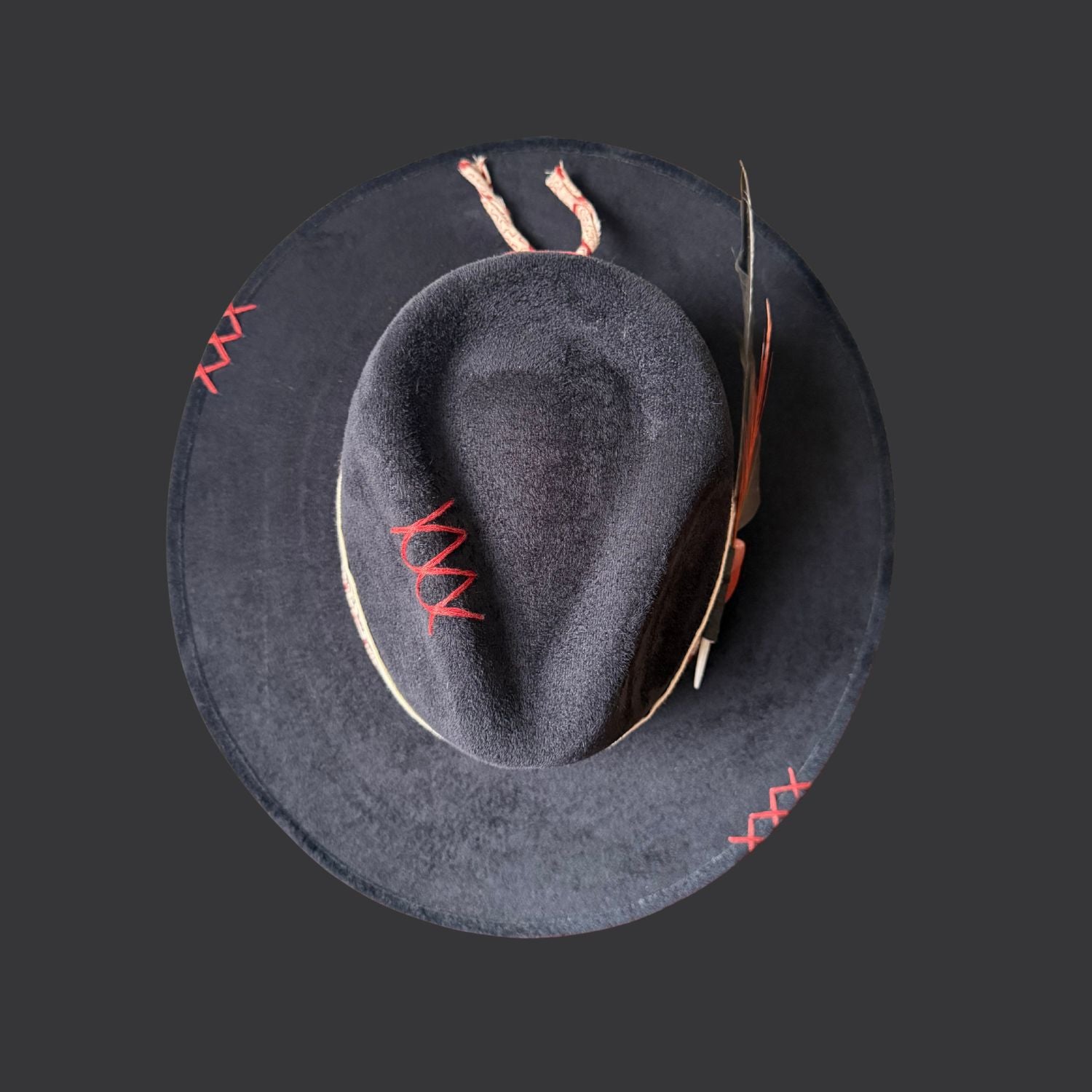 Top view of one of a kind black fedora hat with red jasper, embroidered details, and feather accents