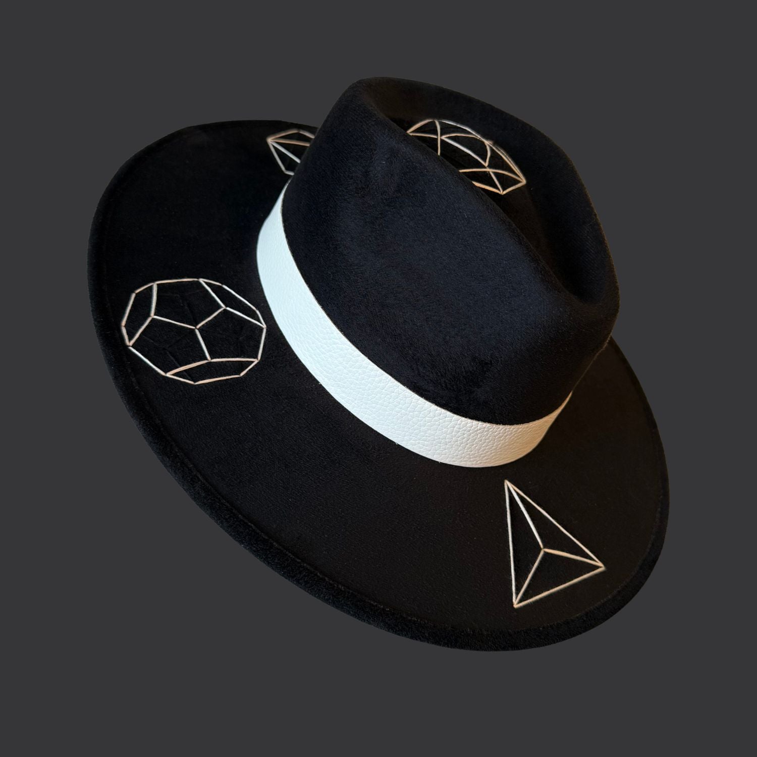 Black suede wide brim fedora with tree agate crystal, white leather band, and green black white duck feather / left side view
