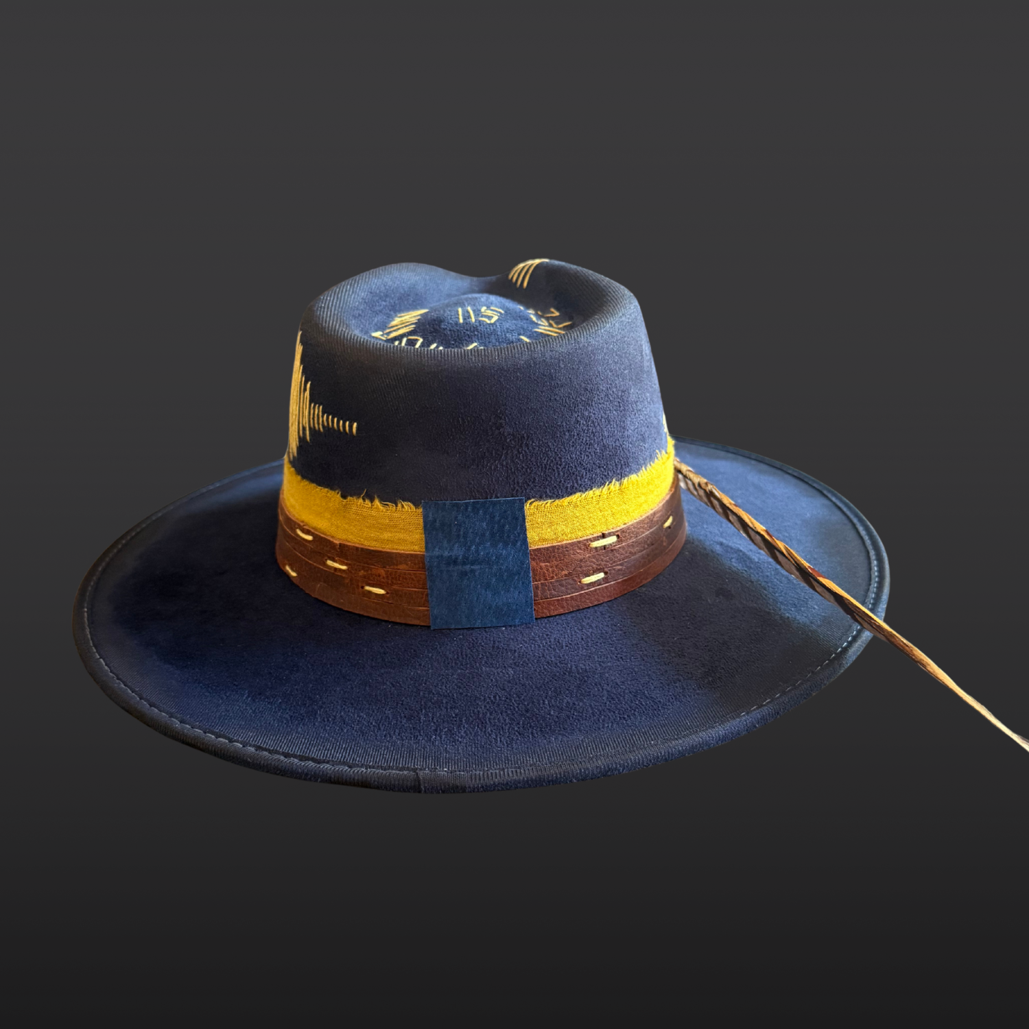 Back side view of navy festival hat with hand-embroidered sound wave design and yellow stitching.