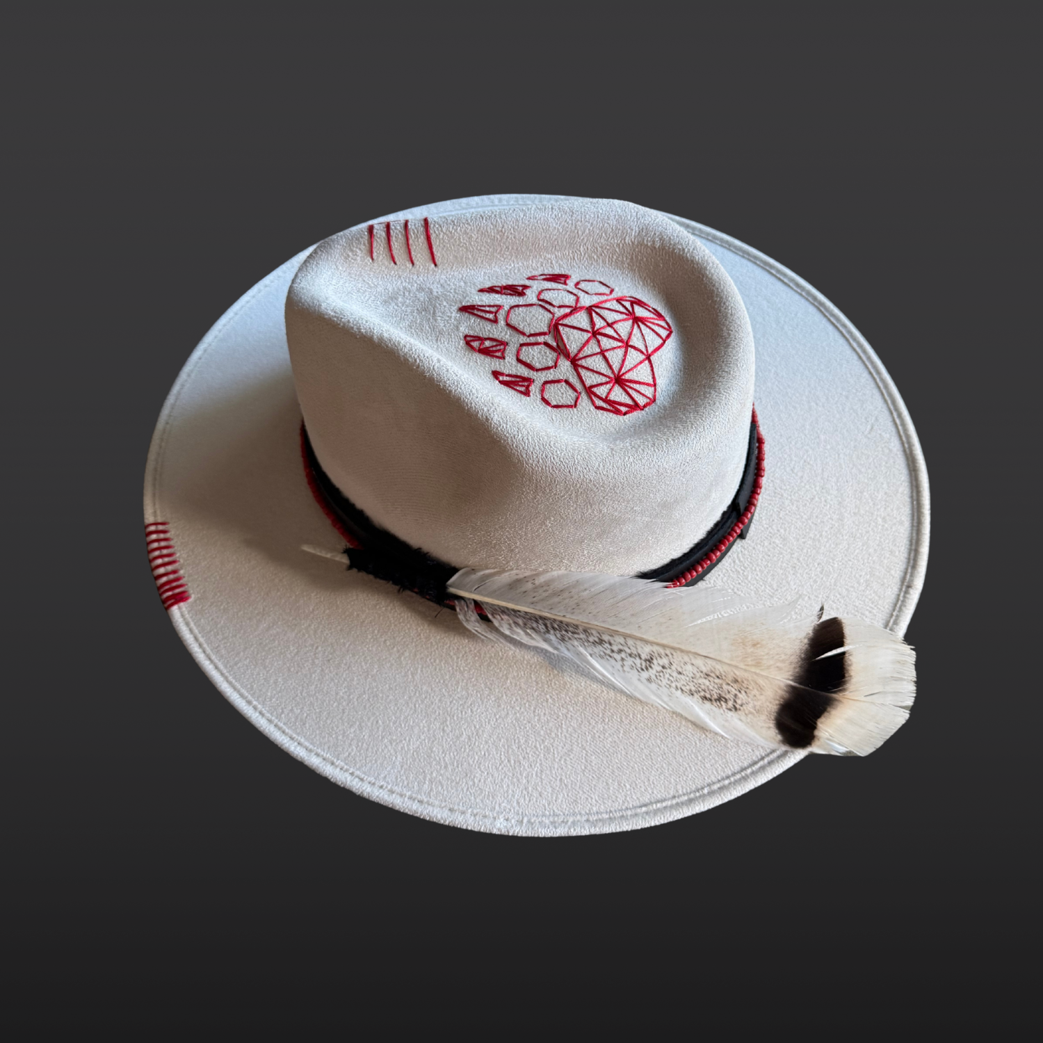 Top side angled view of Ivory vegan suede fedora with a black hat band and red bead accents.