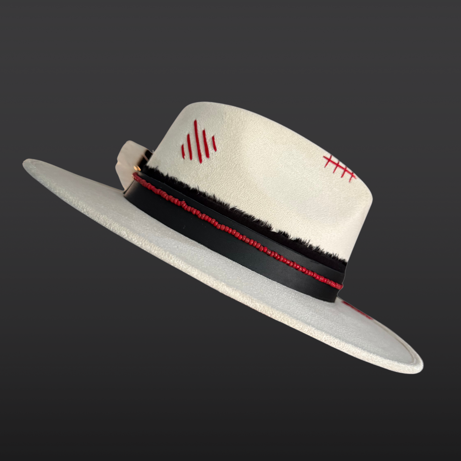 Left side view of Ivory vegan suede fedora with a black hat band and red bead accents.