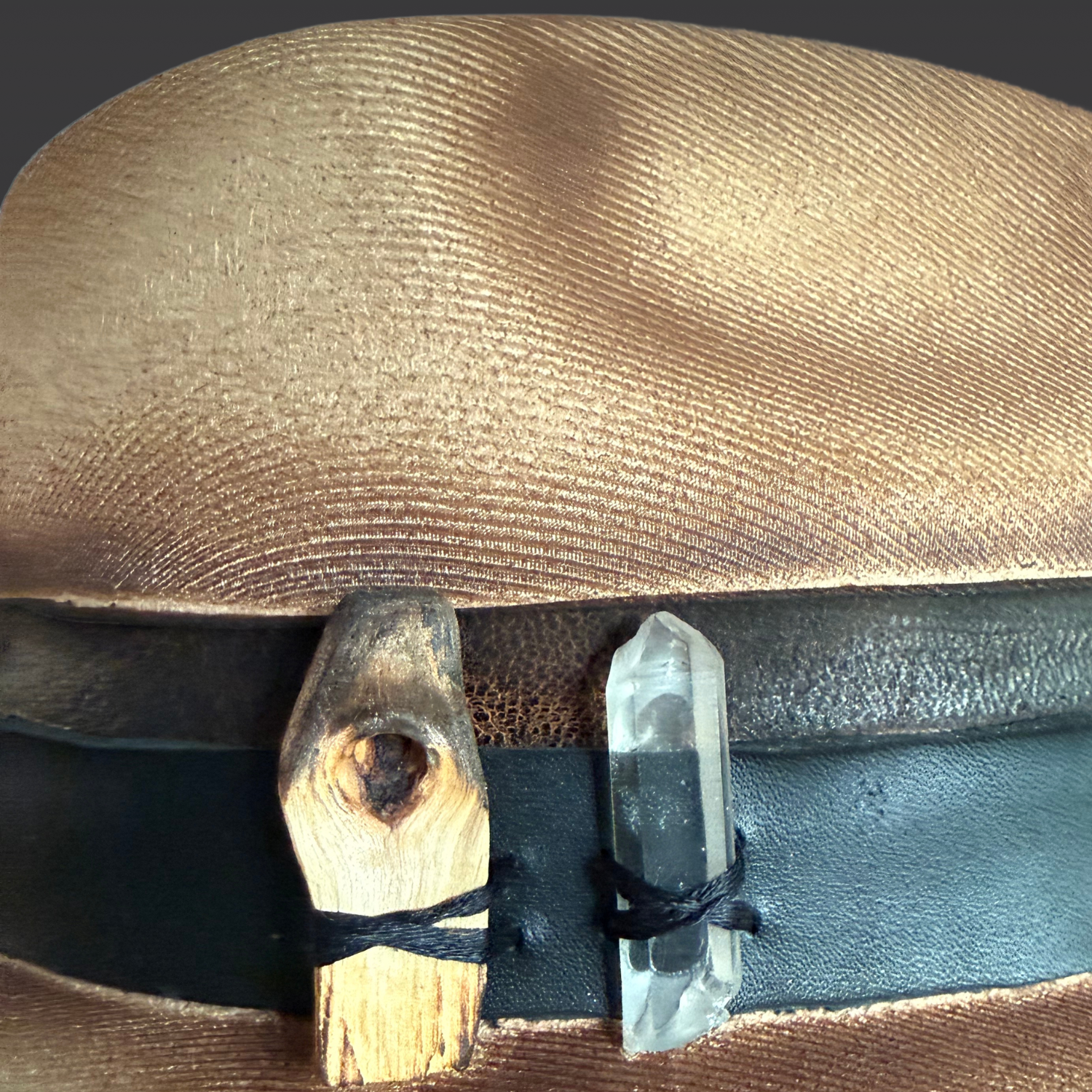 Close-up of genuine Clear Quartz crystal and Palo Santo on the Firekeeper artisan fedora