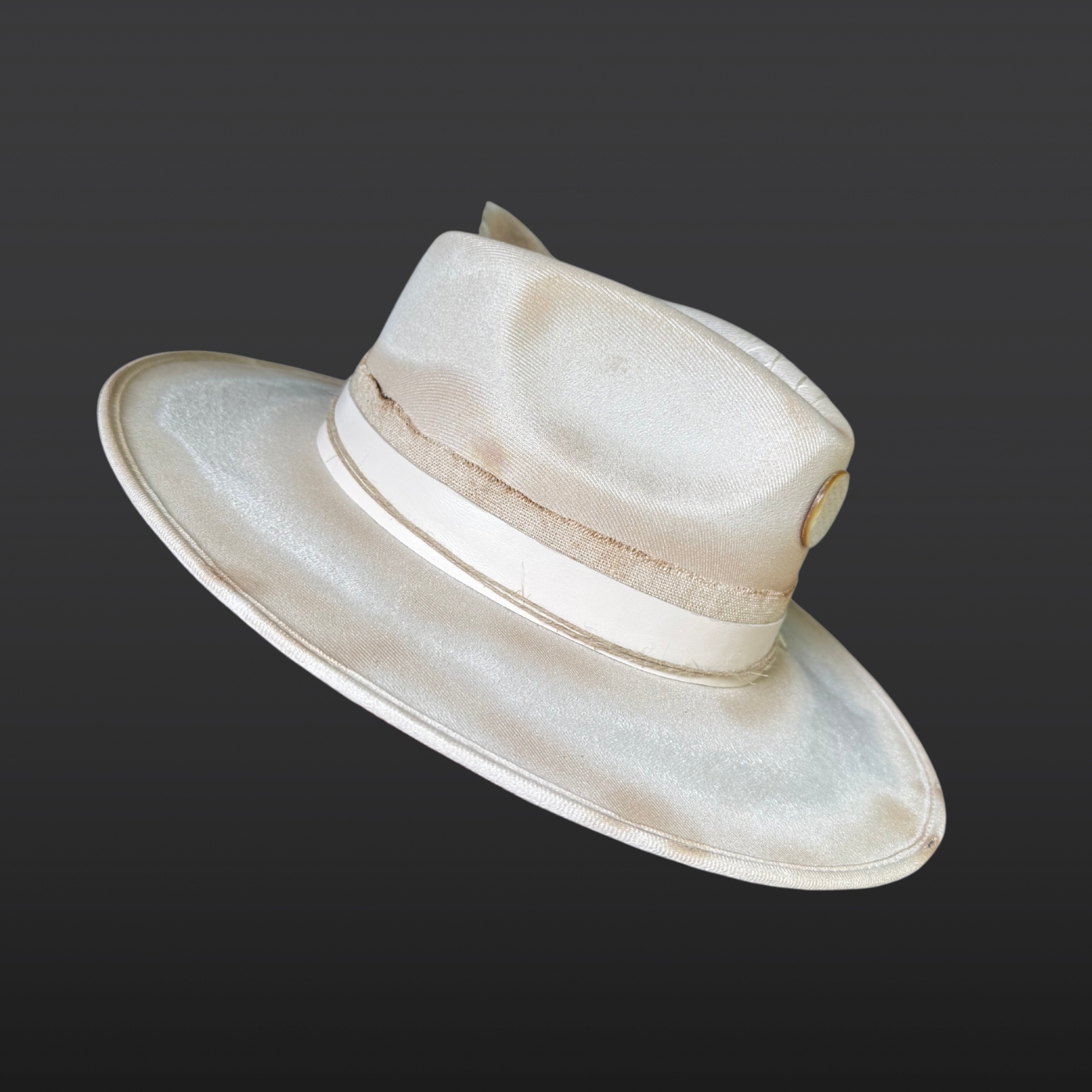 Left side view of Burnished ivory wide-brim fedora by Inara Hat Co. featuring hand-burned detailing, a carved Flower of Life shell, layered organic bands, and an ethically sourced feather.