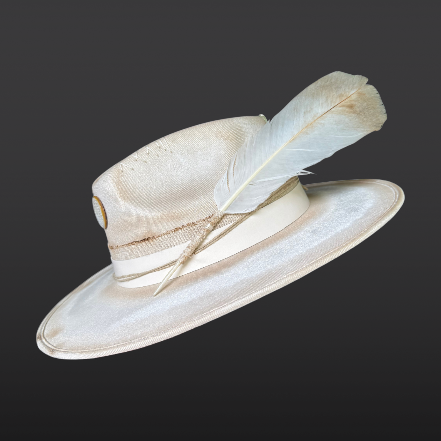 Right side view of Burnished ivory wide-brim fedora by Inara Hat Co. featuring hand-burned detailing, a carved Flower of Life shell, layered organic bands, and an ethically sourced feather.