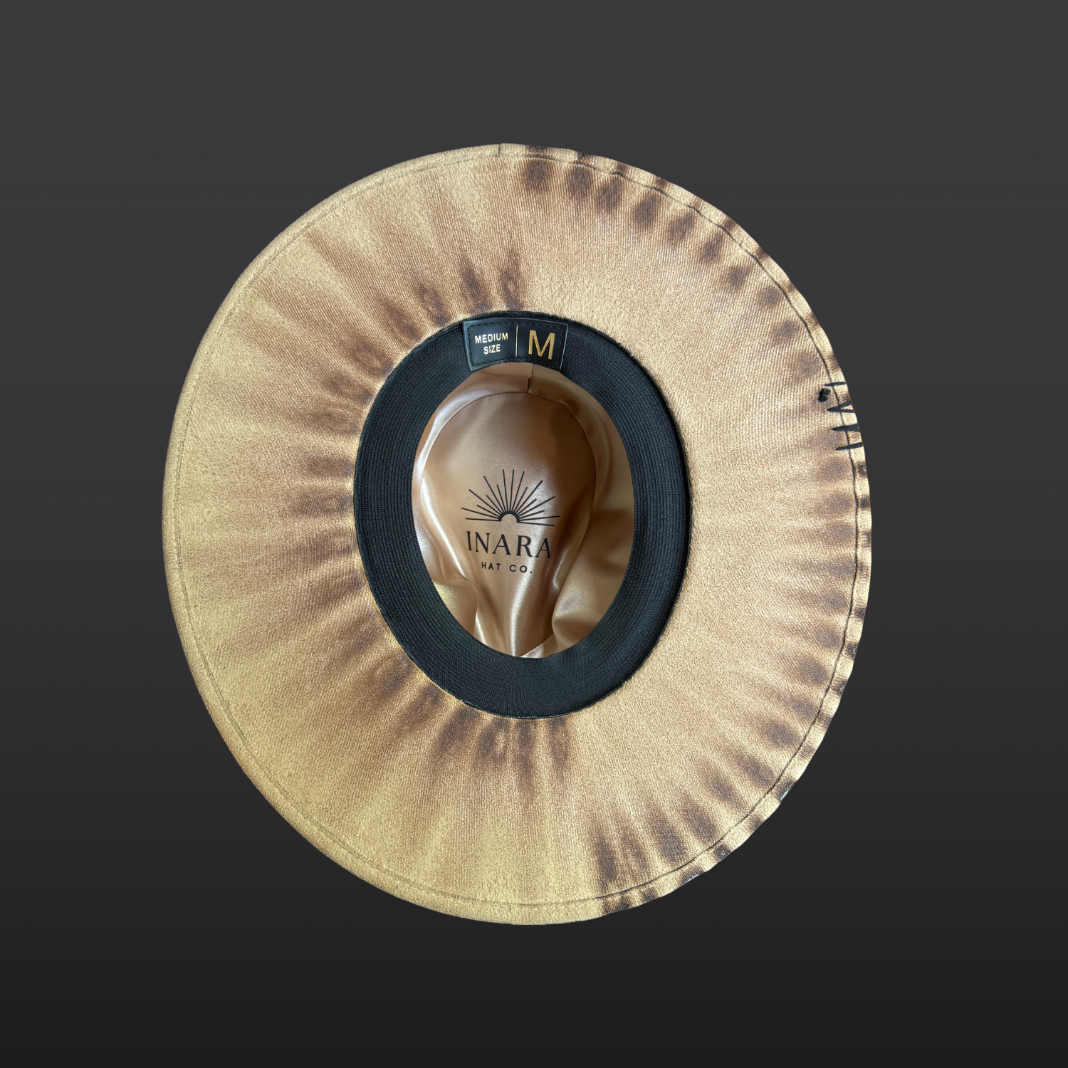 Bottom view of the Transmutation camel vegan suede fedora featuring black leather band, serpent print detail, and turkey feather.