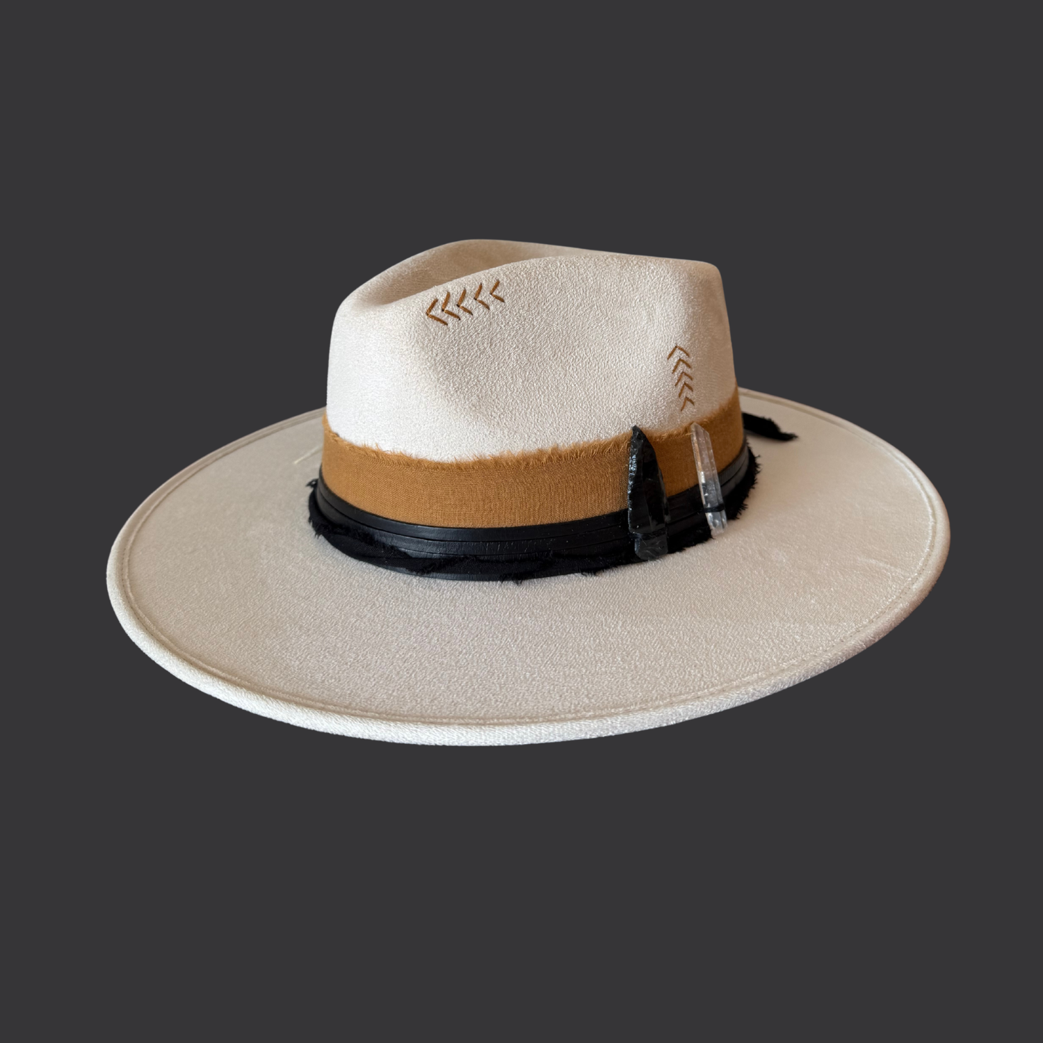 Close-up of Lemurian quartz and black obsidian arrow on ivory fedora hat