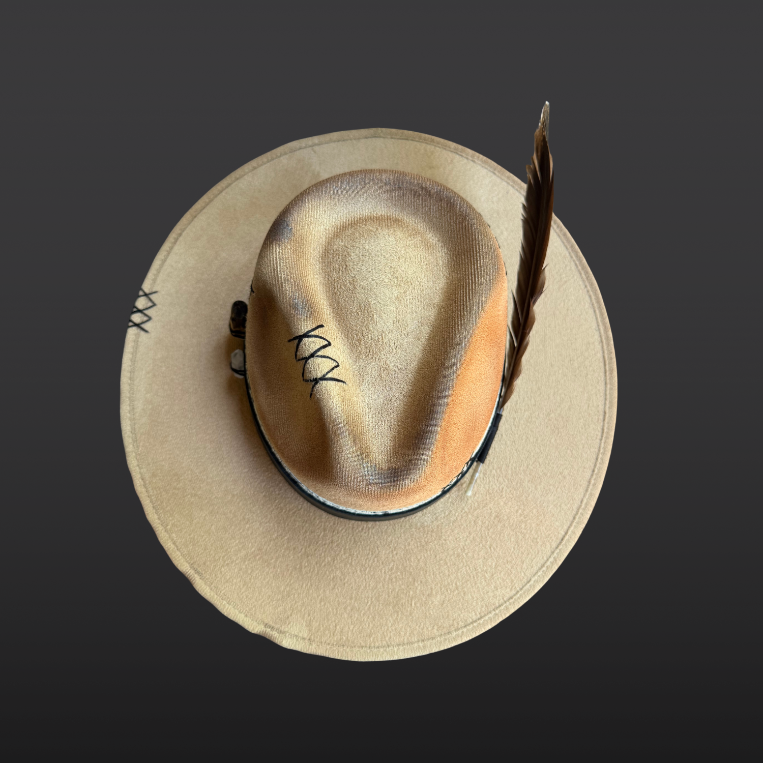 Top view of camel vegan suede fedora with structured crown and layered black leather and serpent print leather bands.