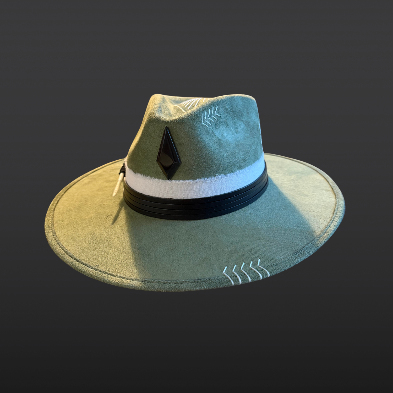 One of a kind sage green artisan fedora hat with obsidian stone, black leather band, white cotton wrap, feather detail, and hand embroidered directional symbols by Inara Hat Co.
