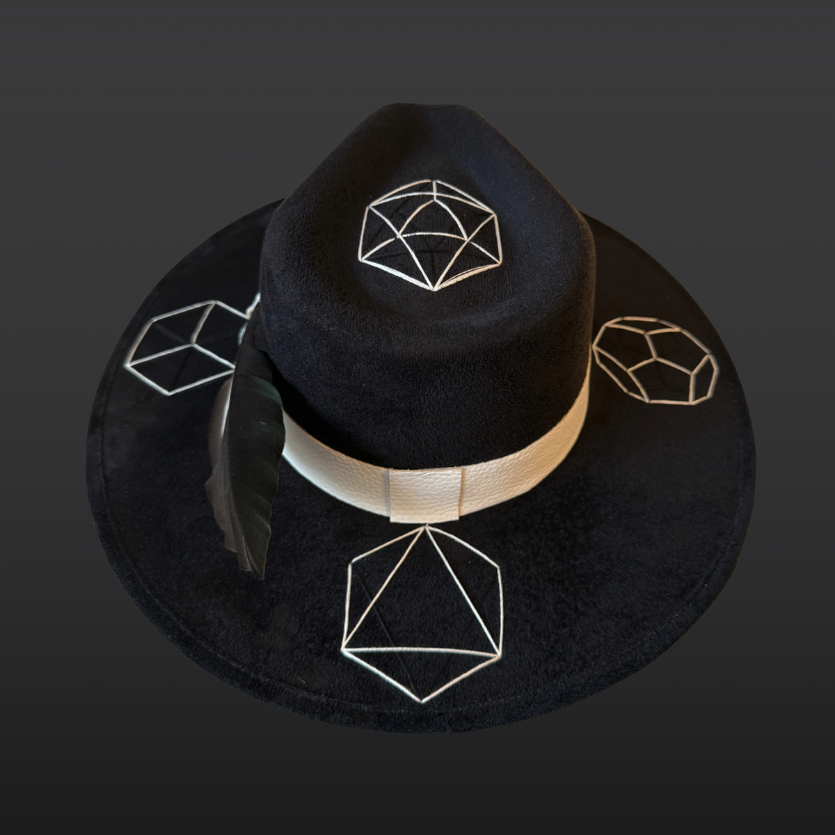 Back view:
A wide-brimmed black fedora shown from the back, featuring a white leather band and green, black, and white duck feather accent.