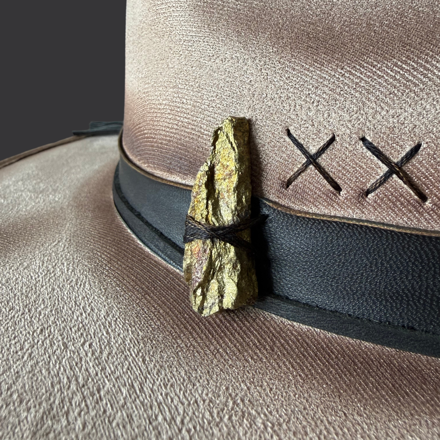 Close-up of chalcopyrite crystal on khaki vegan suede hat
