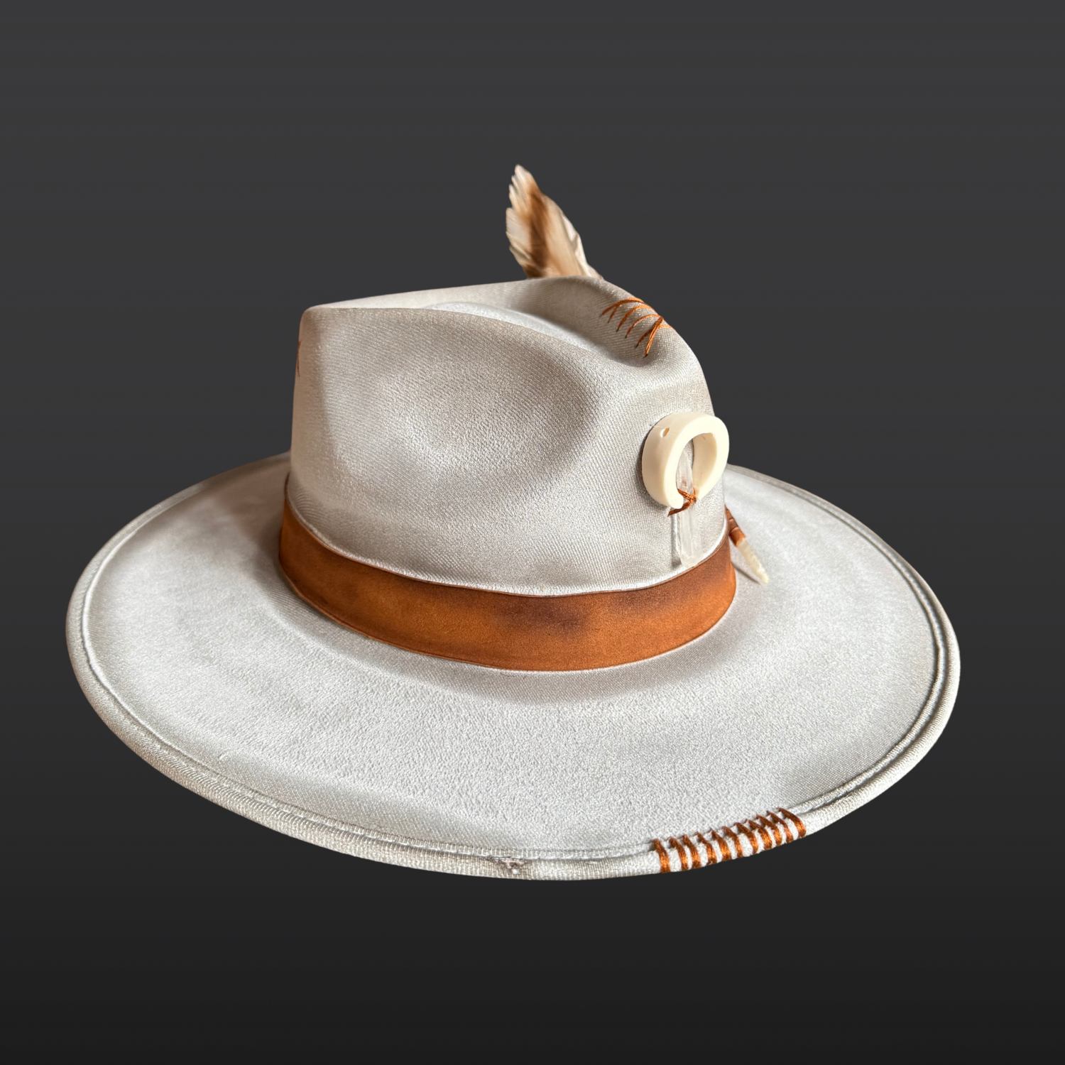 Left side of grey wide brim fedora with tobacco leather band and hand embroidery
