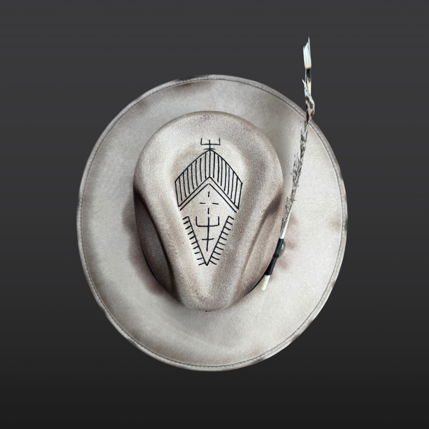 Top view of Ember Guardian wide brim fedora hat showing pyrite crystal, turkey feather, and symbolic embroidery details.