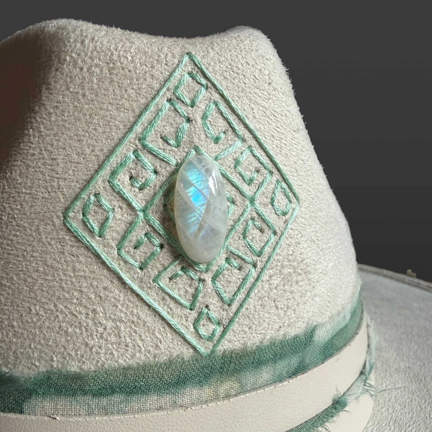 Close-up of genuine Moonstone set within the hand-embroidered diamond design on the Lumina fedora