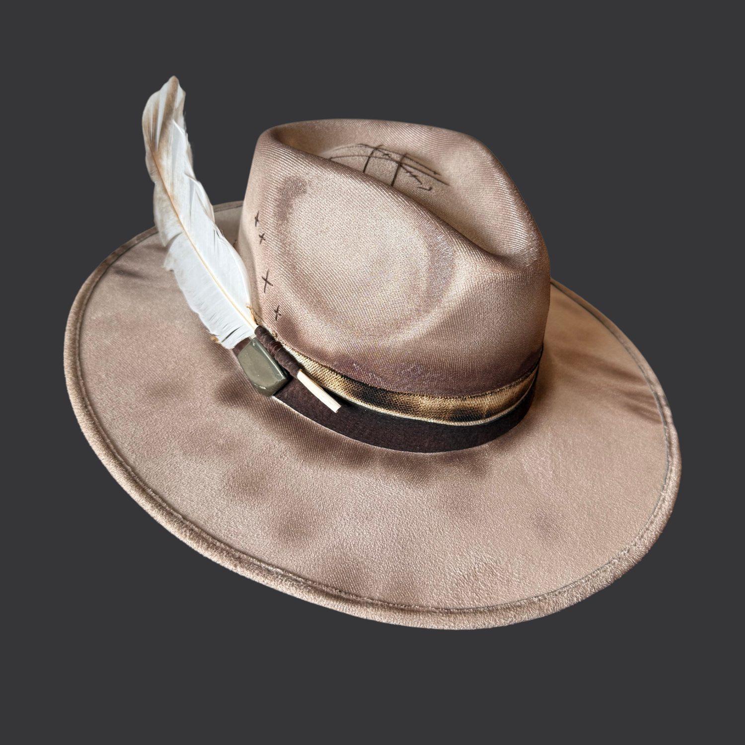 Side view of khaki fedora hat with pyrography detailing and pyrite accent