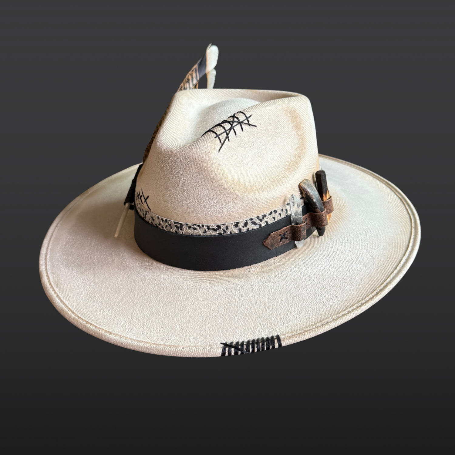 Front view of Unbound ivory wide brim fedora hat featuring black embroidered details and a rugged hand-torched finish.