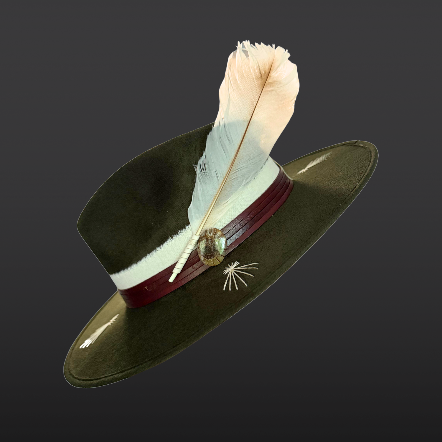 Alternate left Side view of Kindred forest green fedora hat with ivory embroidery, leather band and fossil ammonite