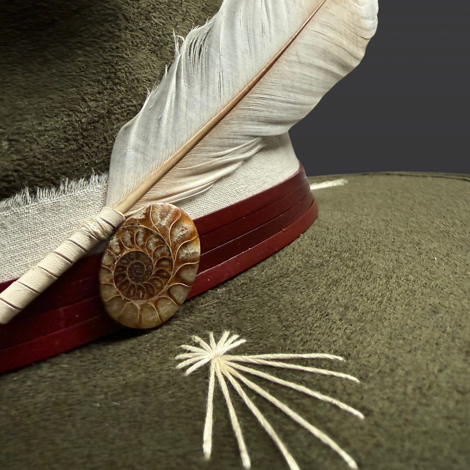 Close up details on the Kindred fedora hat of fossil ammonite and ethically sourced turkey feather