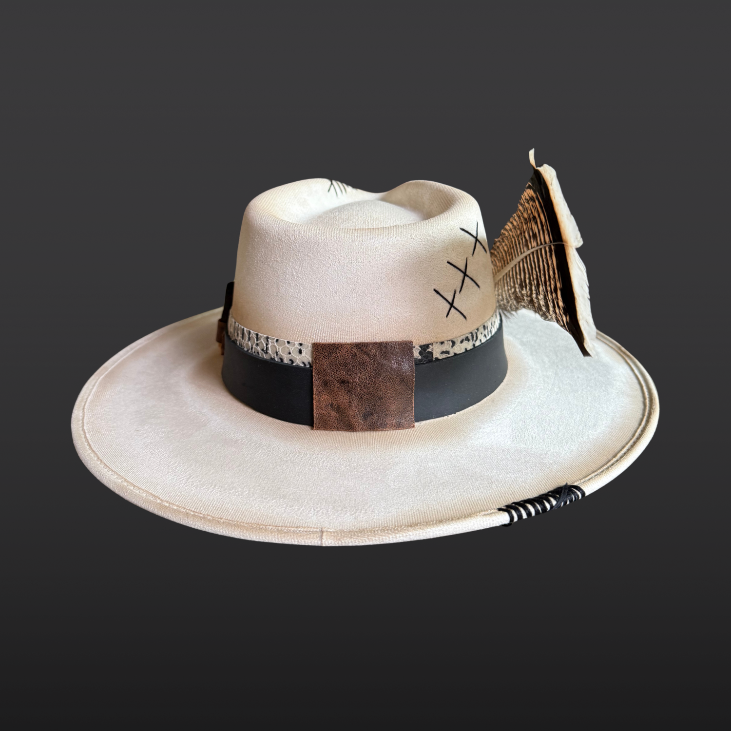 Back side view of Unbound ivory wide brim fedora hat featuring black embroidered details and a rugged hand-torched finish.