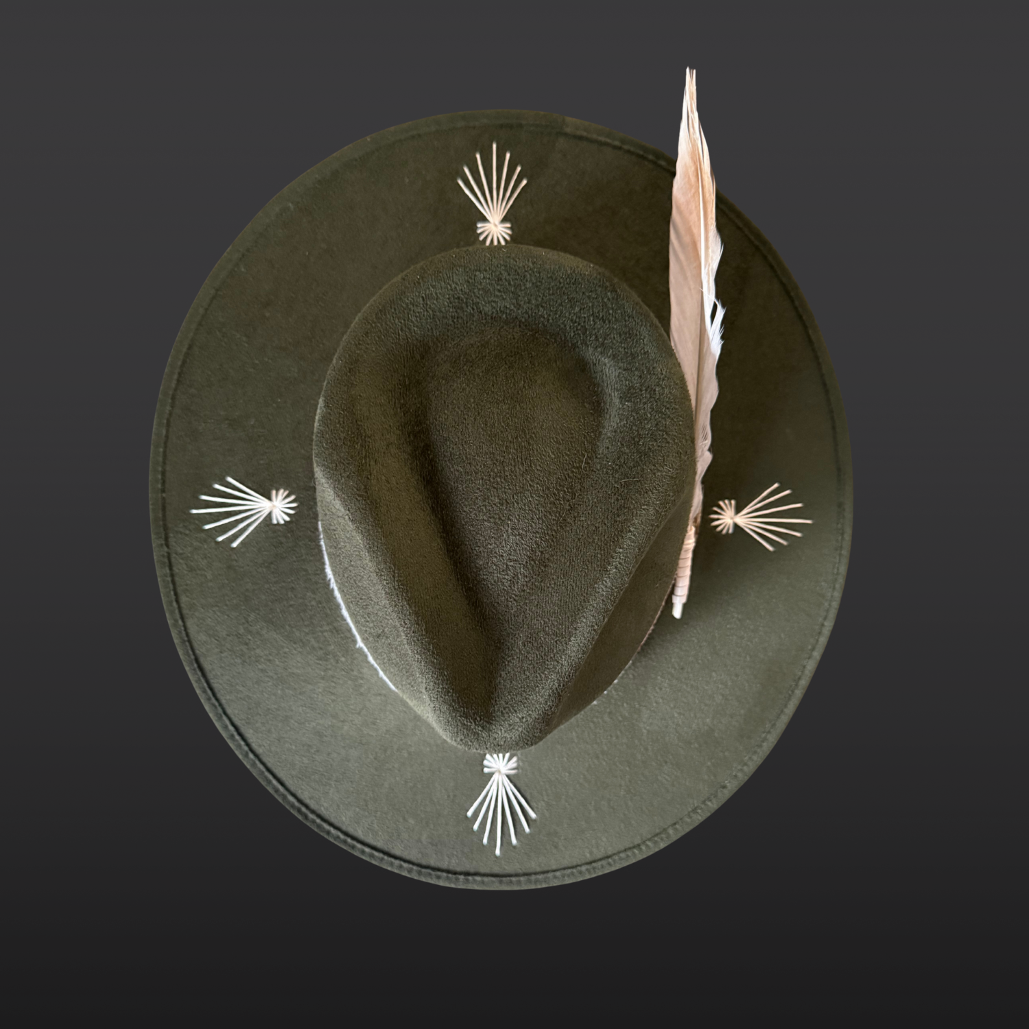Top view of the Kindred forest green fedora hat showing ivory embroidered bursts across the brim and layered leather band