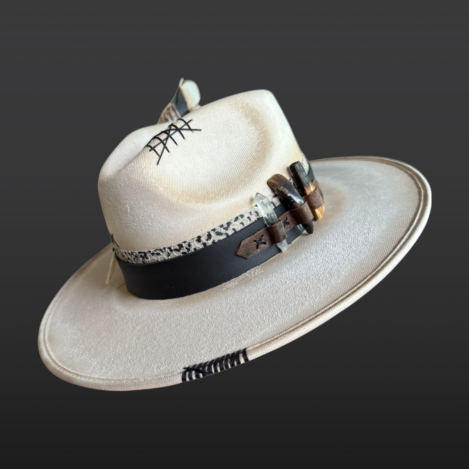 Unbound one-of-a-kind ivory wide brim fedora hat with hand-torched finish, layered leather bands, embroidery, quartz crystal, bison tooth, Palo Santo, and turkey feather.