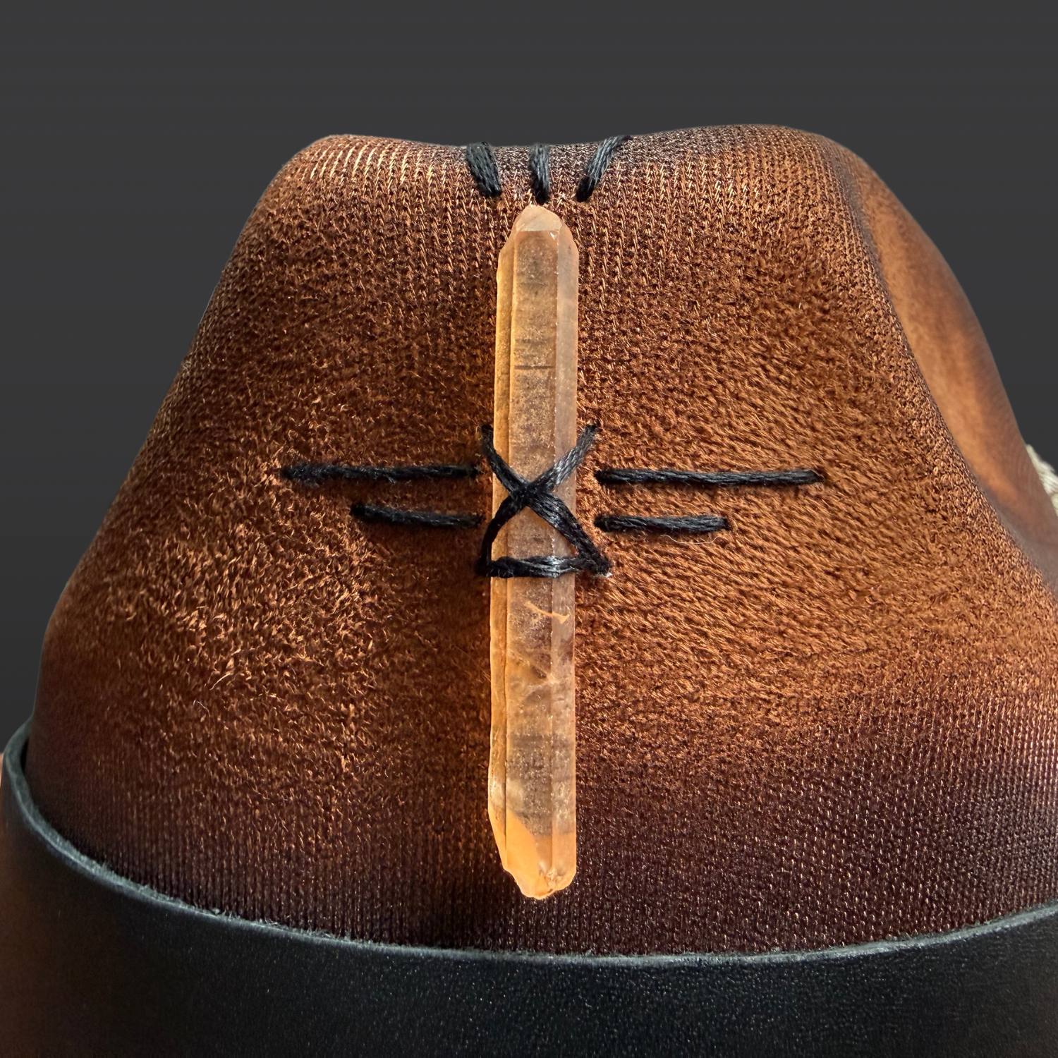 Close-up of tangerine quartz crystal point and hand-embroidered detailing on Wild in the Woods fedora hat