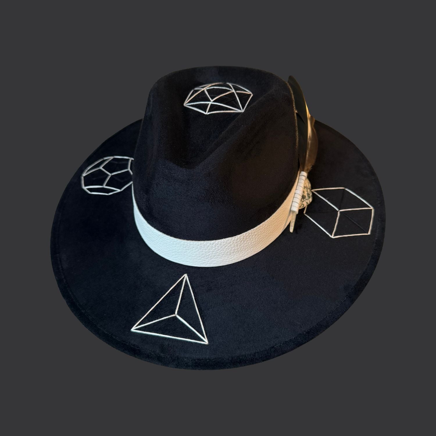 Black suede wide brim fedora with tree agate crystal, white leather band, and green black white duck feather / front view