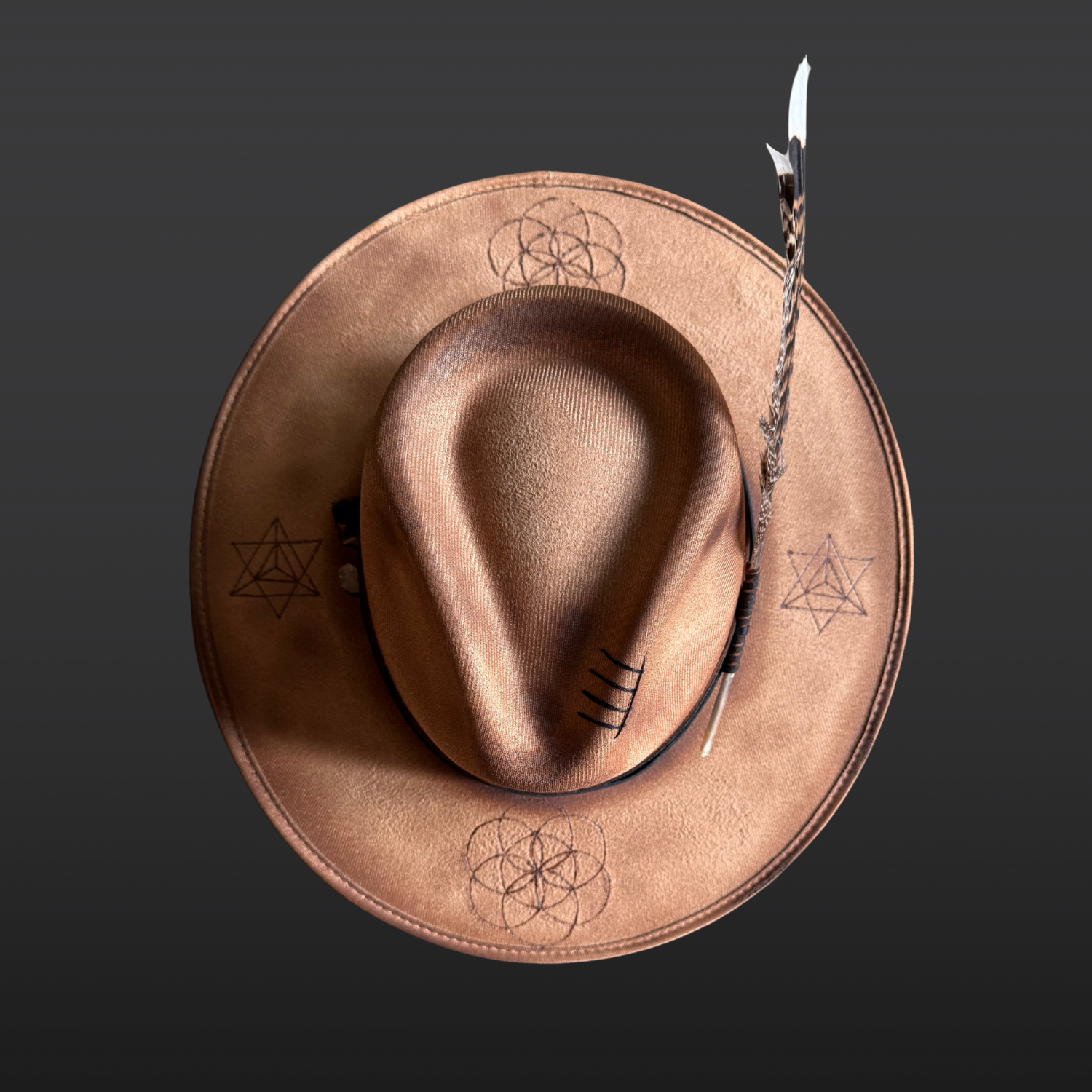 Top view of camel wide brim fedora with Palo Santo, Clear Quartz, turkey feather, and distressed leather bands