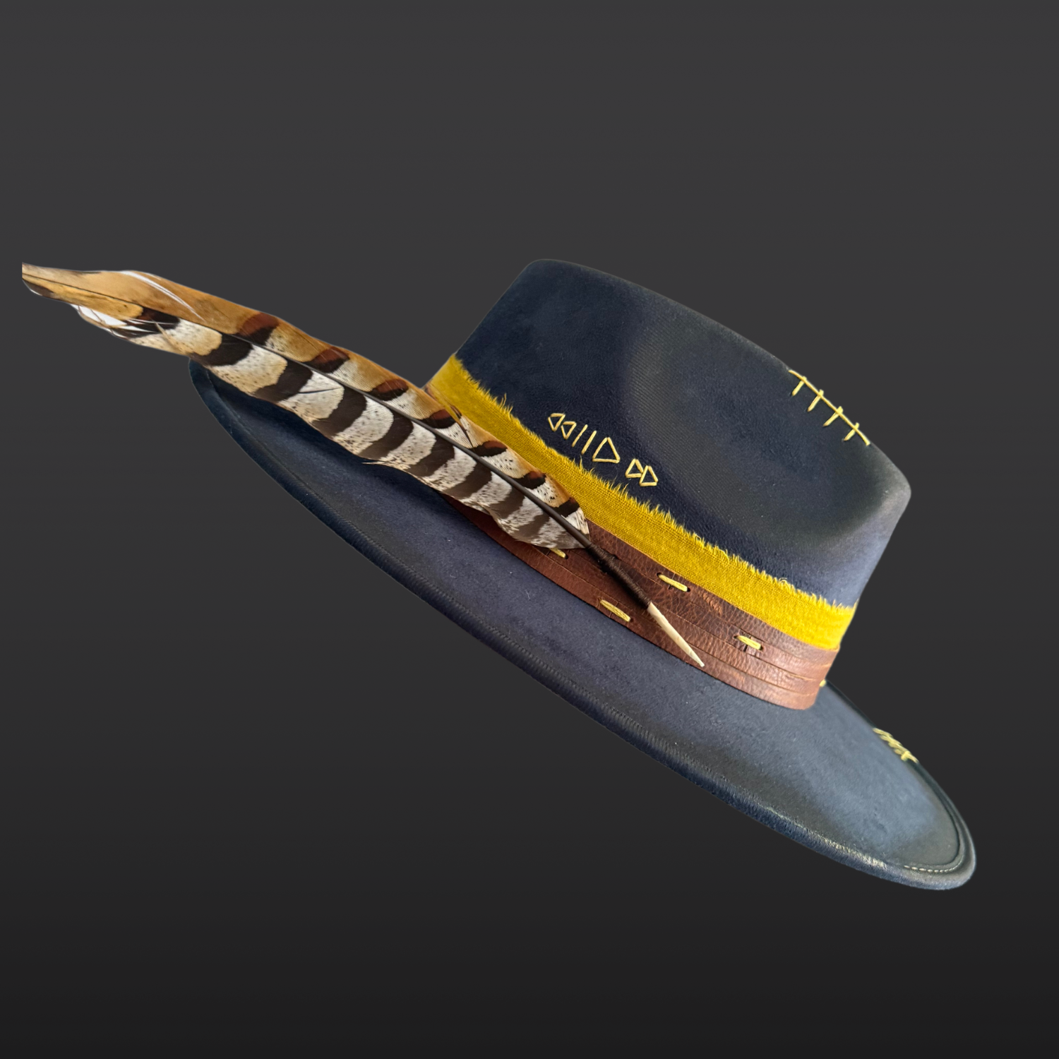 Close-up of ethically sourced pheasant feather attached to a navy statement fedora.