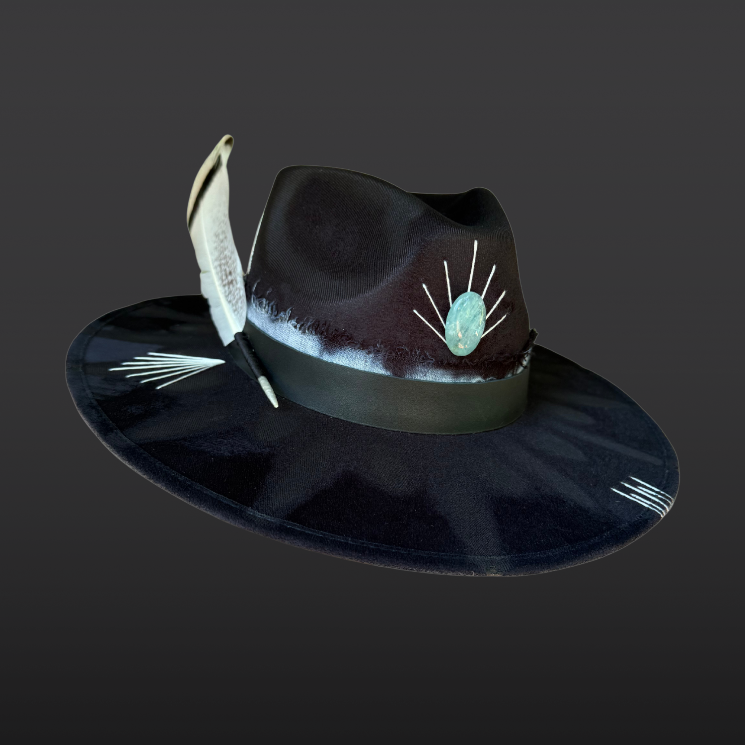 Front angle view of Ocean Within black wide brim fedora with aquamarine stone, black leather band, aqua and turquoise cotton band, turkey feather, and hand embroidered accents by Inara Hat Co.