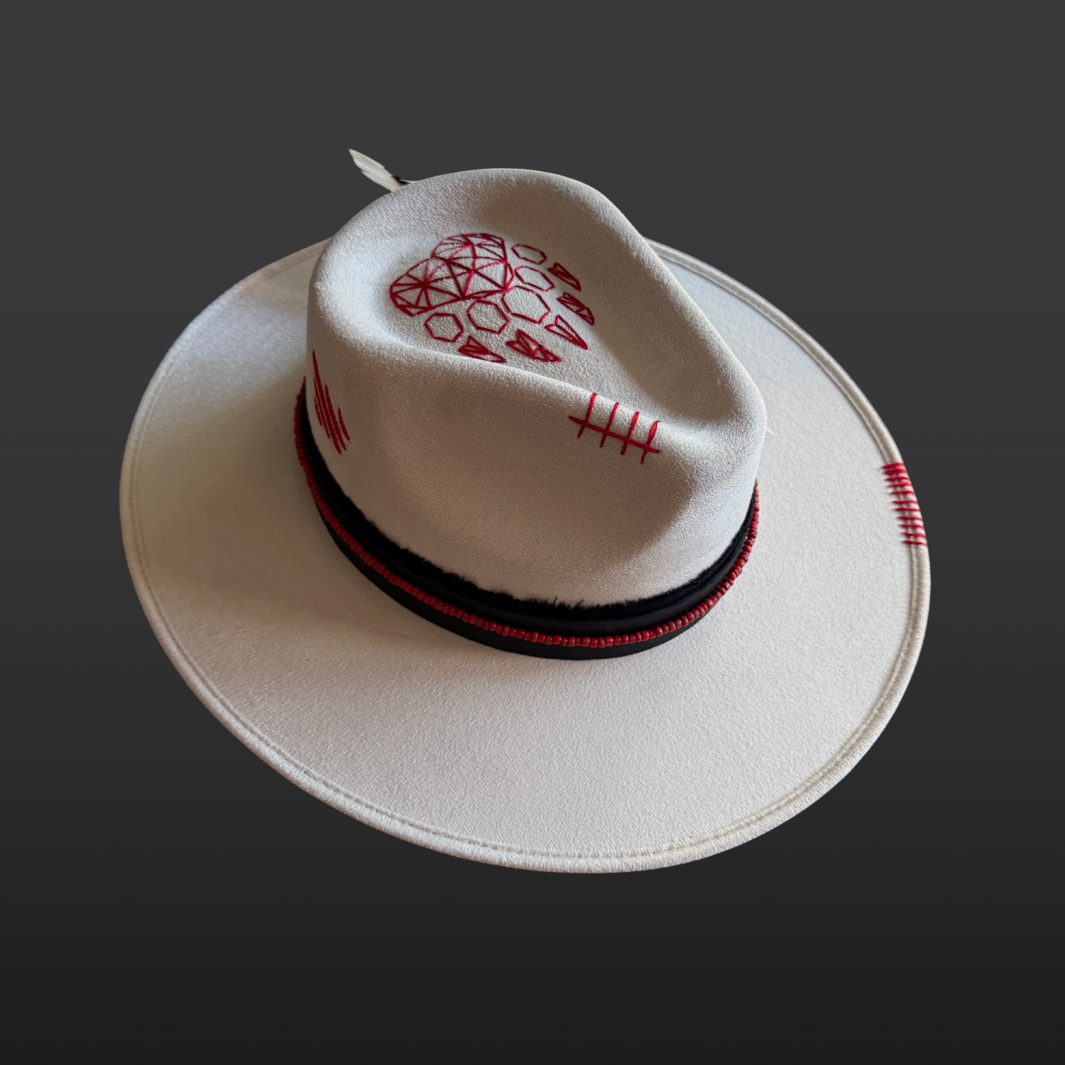 Left side view of Ivory vegan suede fedora with a black hat band and red bead accents.