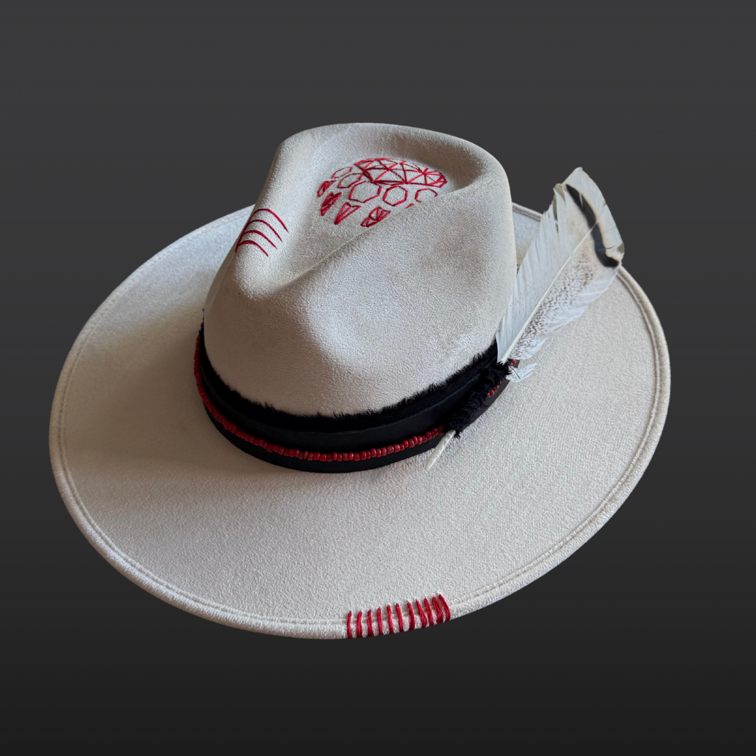 Ivory wide brim fedora hat with a black band, red beads, and a geometric bear paw embroidery.