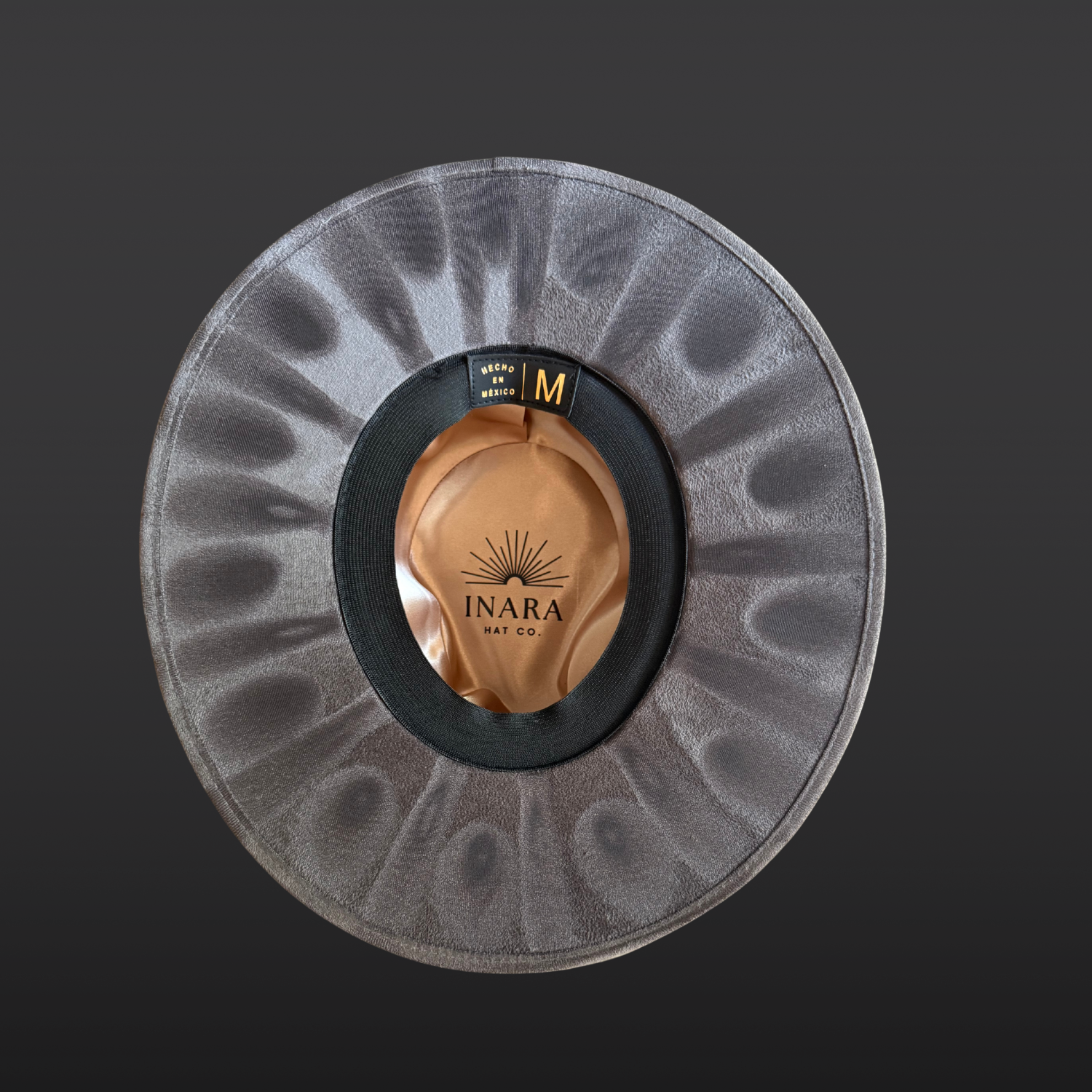 Hand-torched detailing beneath the brim of a gray statement hat.