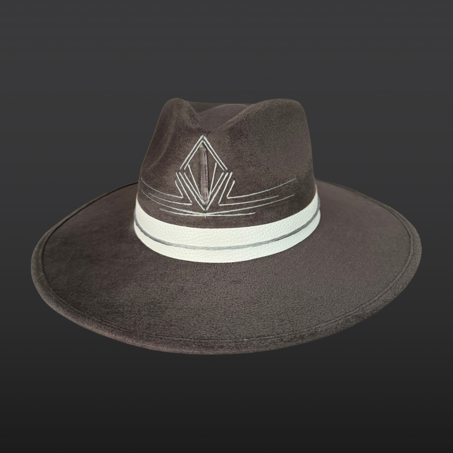Front view of a gray statement fedora featuring a hand-embroidered silver triangle and Lemurian quartz crystal.