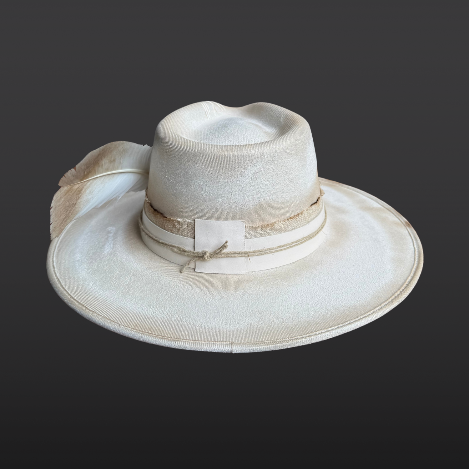 Back side view of Burnished ivory wide-brim fedora by Inara Hat Co. featuring hand-burned detailing, a carved Flower of Life shell, layered organic bands, and an ethically sourced feather.