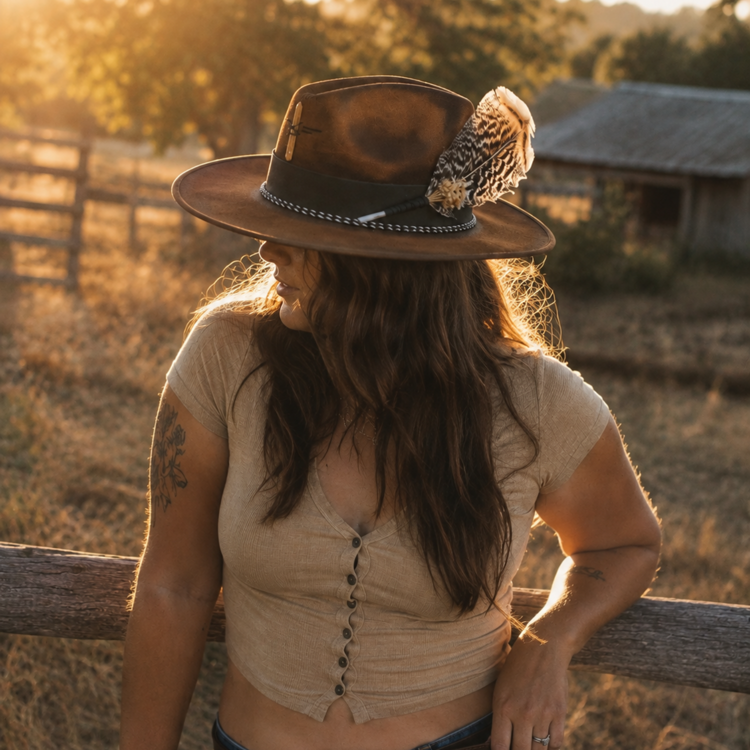 Woman wearing Wild in the Woods one-of-a-kind tobacco suede boho fedora hat with tangerine quartz and feather